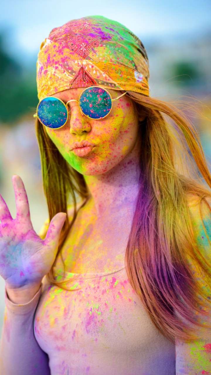 How can you prepare skin and hair before playing Holi?