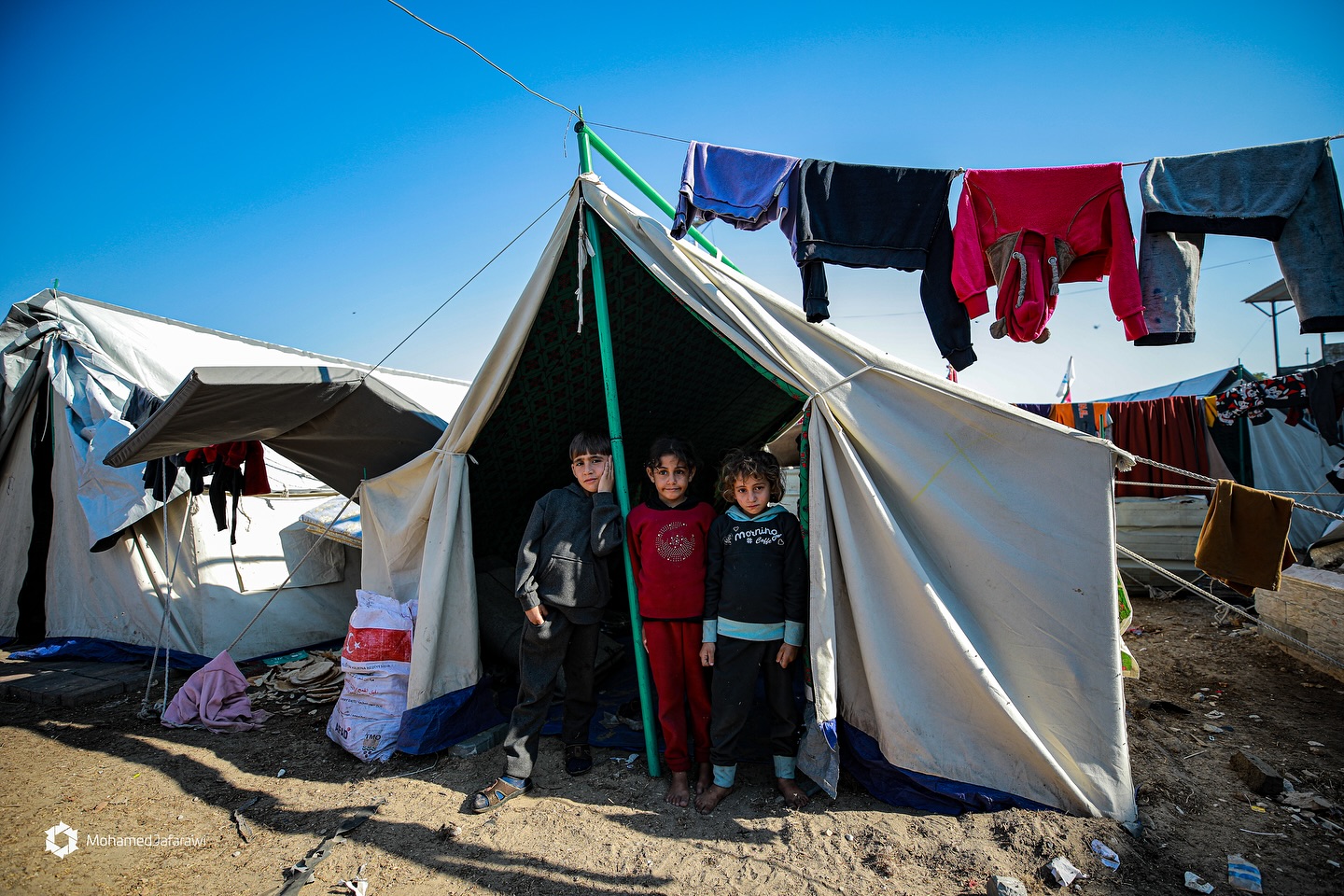.
‏These children stand at the entrance to their dilapidated tent in a displacem… – ryan