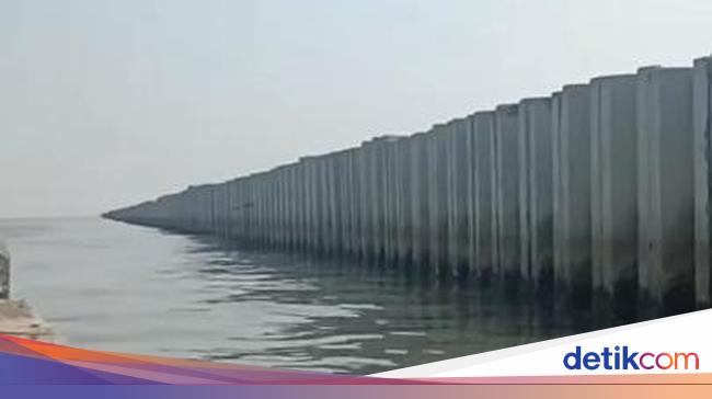 Concrete wall in northern Jakarta mowing question mark