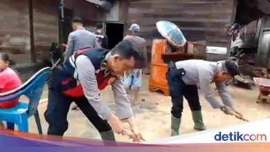 Police help clean up the remaining floods in Suoh West Lampung