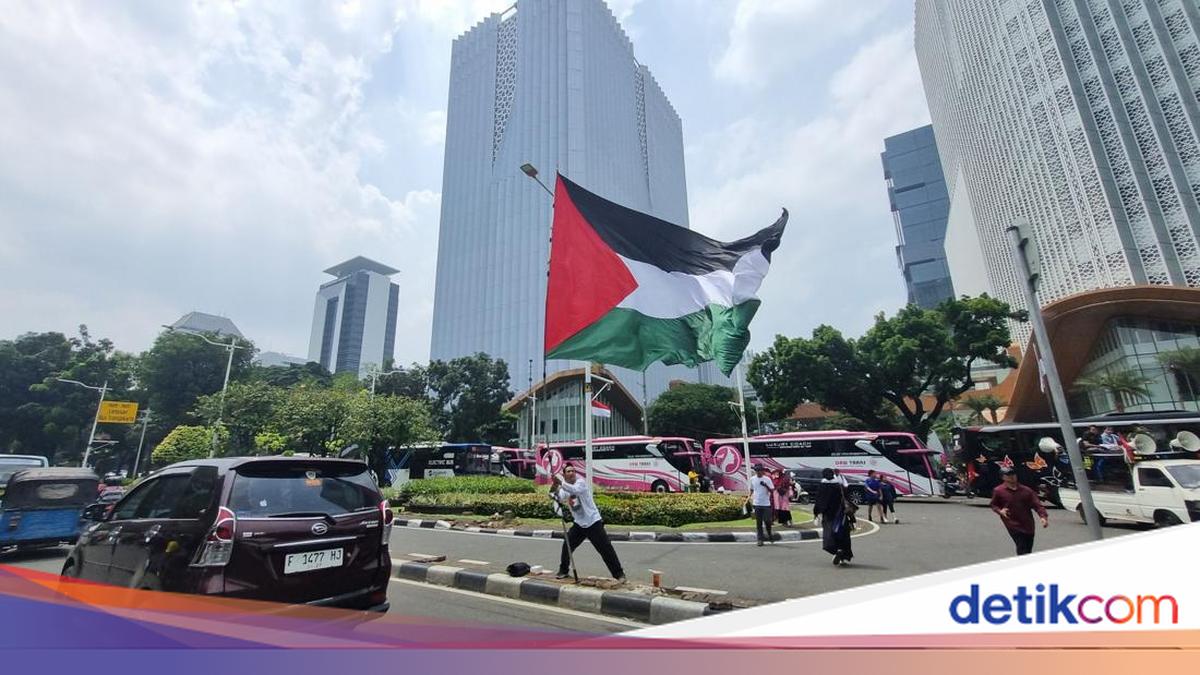 Crowd shouting takbir-bearing large Palestinian flag during the US Embassy demonstration